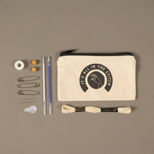 Set of sewing tools including a pouch with a brand logo on a brown background