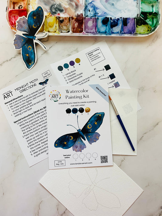 Watercolor painting kit with butterfly design, paint palette, and instructions on a marble surface.