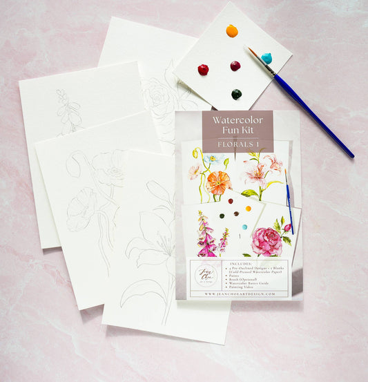 Watercolor Kit with floral designs, paintbrush, and watercolors on a pink background