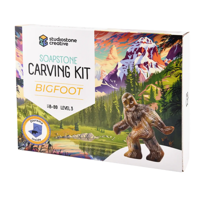 Soapstone carving kit packaging with a Bigfoot figure and mountain landscape illustration.