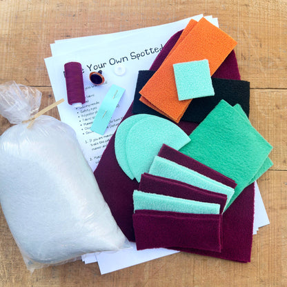 Colorful felt shapes and a white filling on a wooden surface with printed instructions.