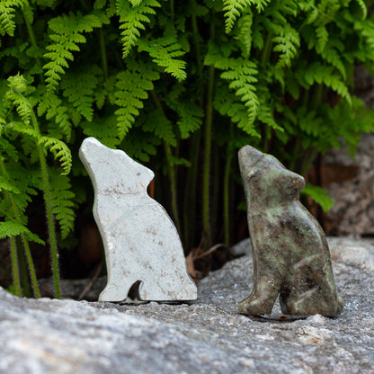 Two wolf carvings from soapstone, the one on the left is a rough cut, and the one on the right has been shaped, smoothed, and has details added in before being polished.