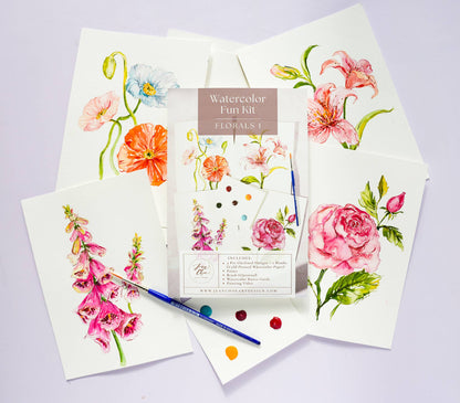 Watercolor Kit with floral designs on paper and a paintbrush on a light purple background