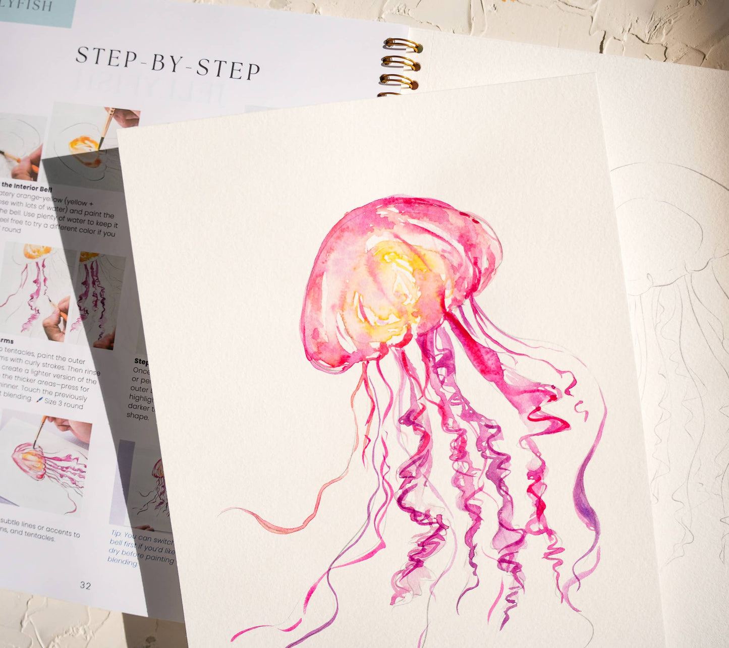 Artistic depiction of a pink jellyfish on a step-by-step art guide