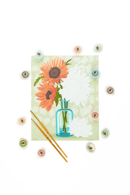 In progress paint by numbers painting of sunflowers in a vase, on a white background.