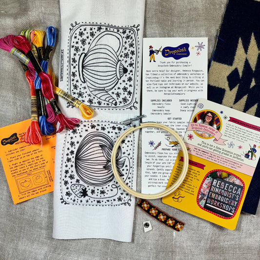 Embroidery kit with patterns, thread, hoop, and instructions on a textured surface