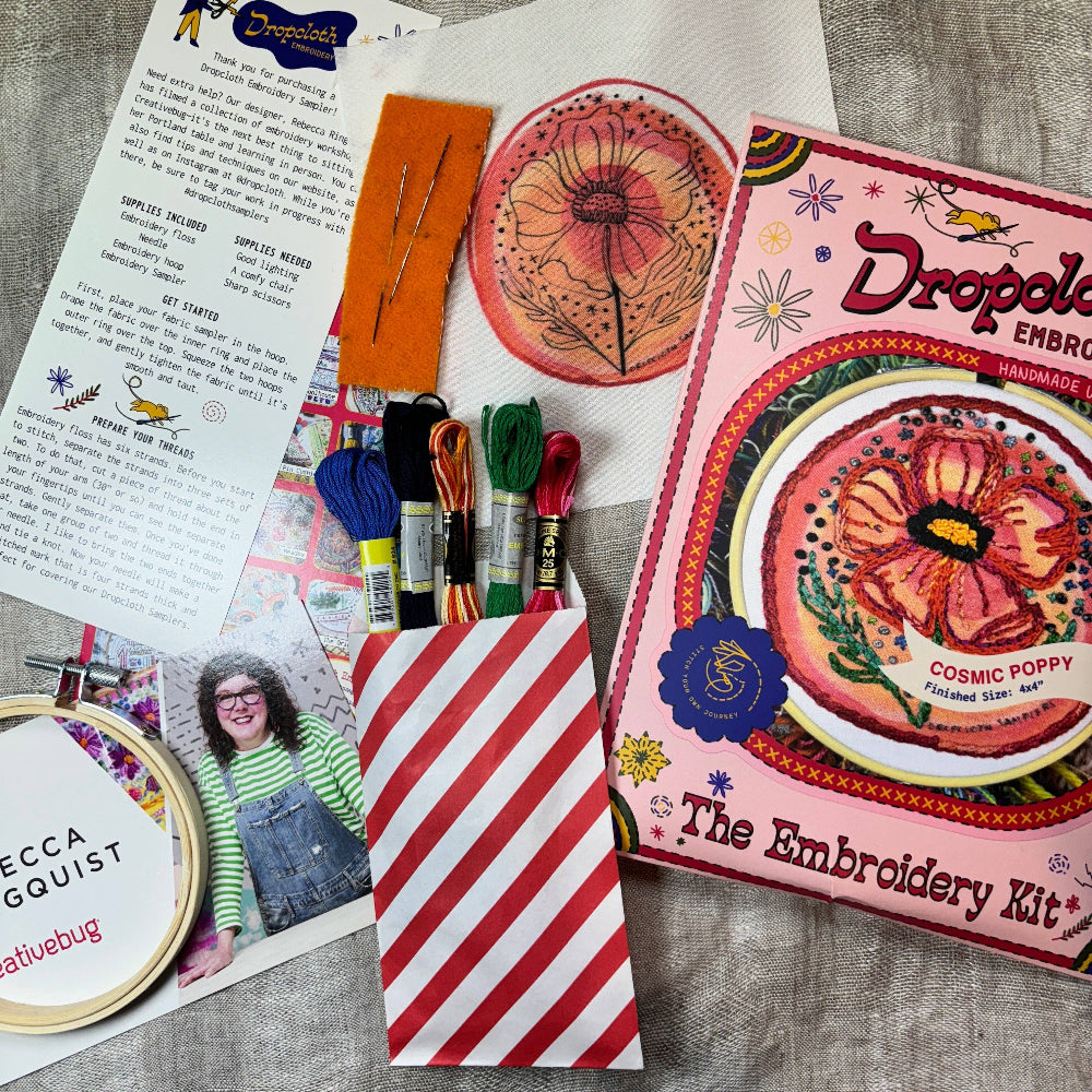 Embroidery kit with materials and instructions on a wooden surface