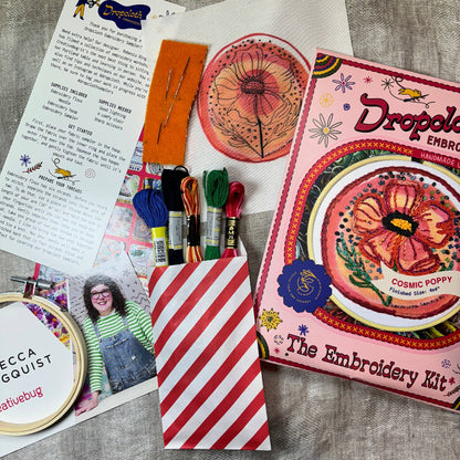 Embroidery kit with materials and instructions on a wooden surface