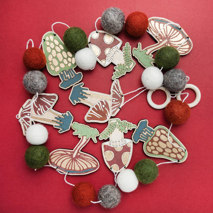 Garland with wooden mushroom shaped cut-outs and felt balls. 