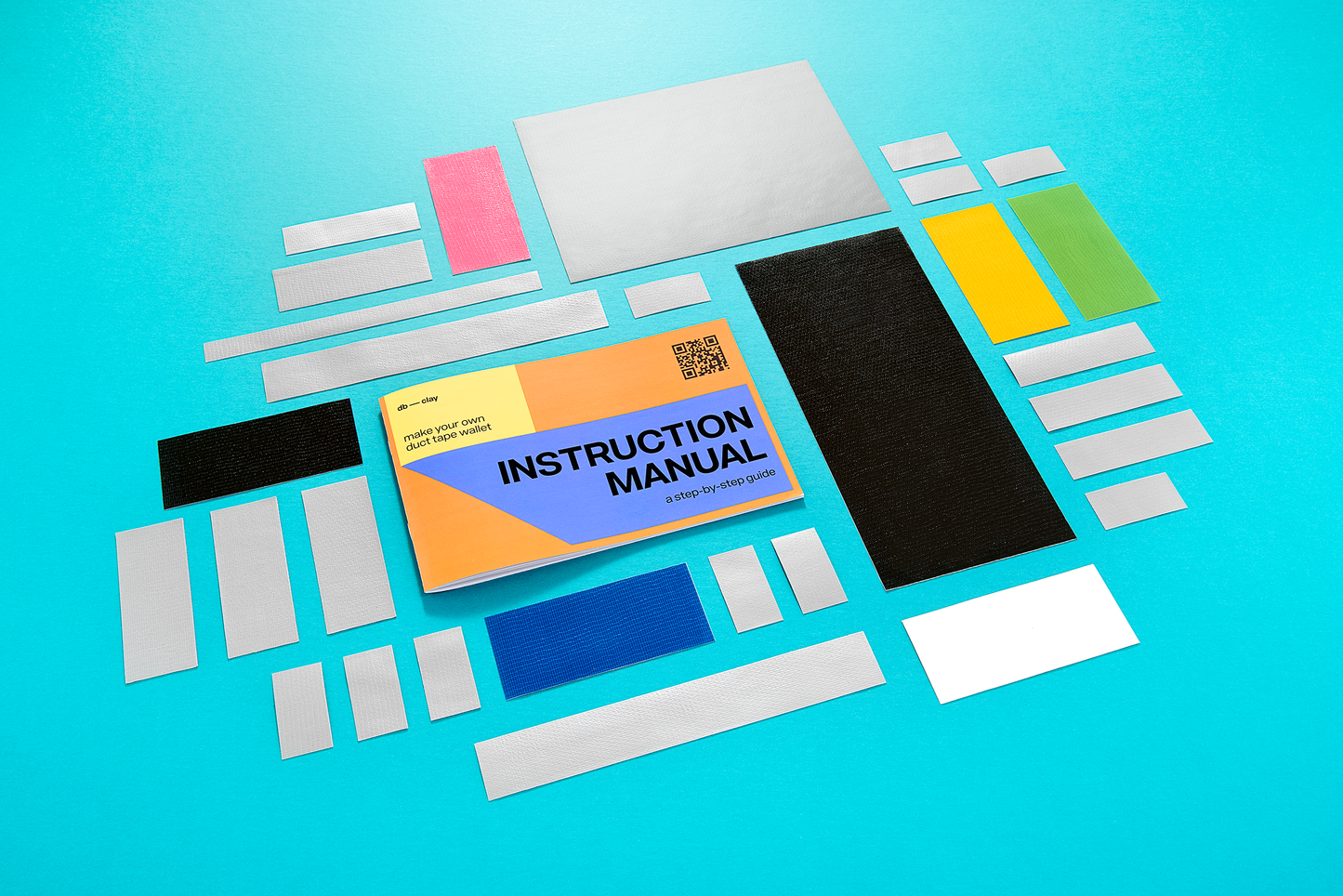Set of colorful pieces of duct tap and an instruction manual on a blue background