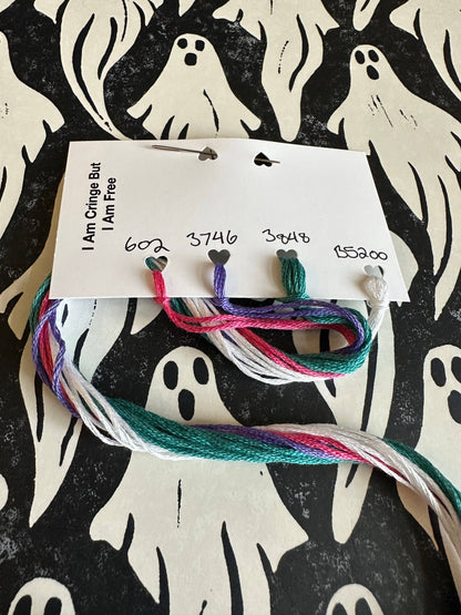Colorful embroidery floss on a card with ghost patterns in the background