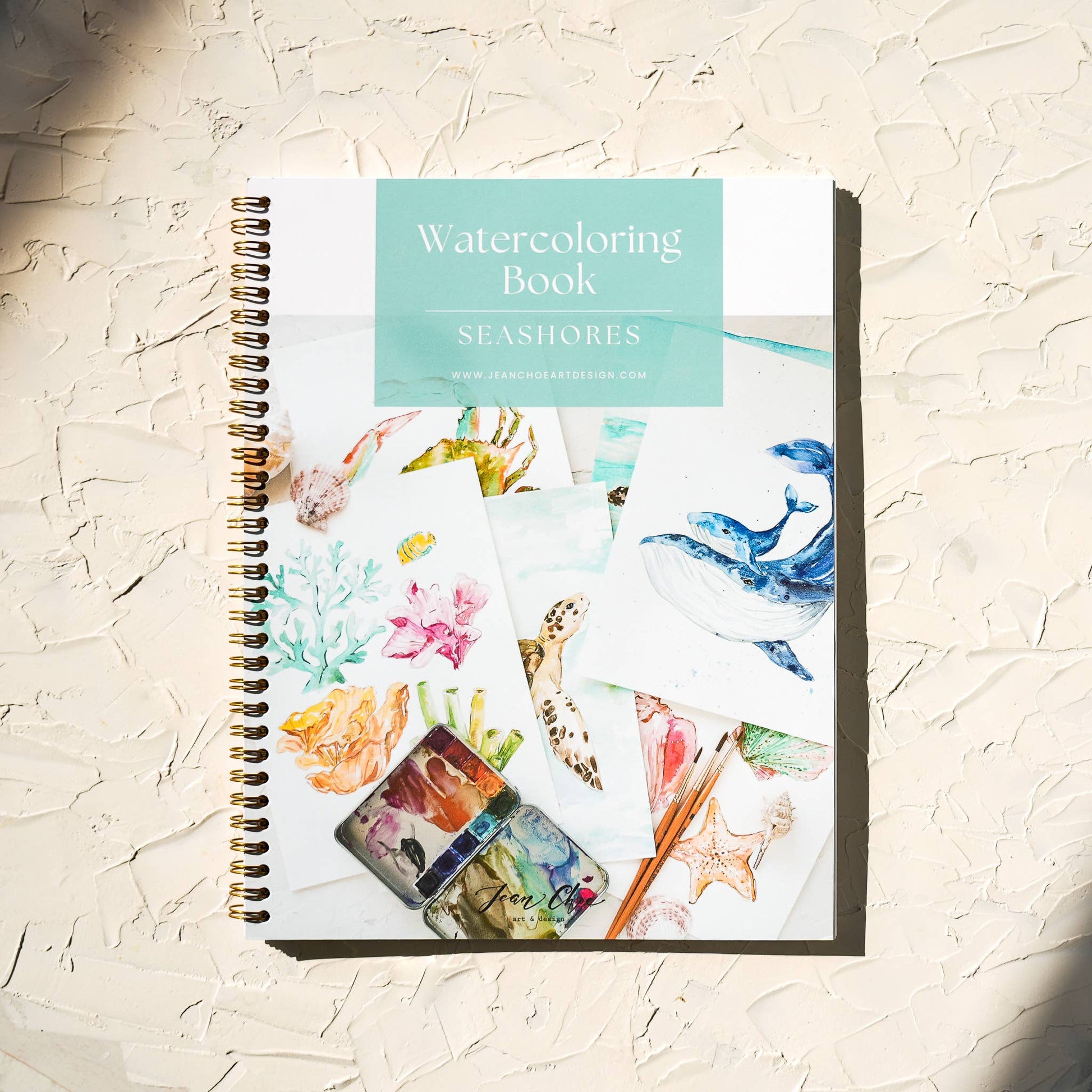 Watercoloring book titled 'Seashores' on a textured surface