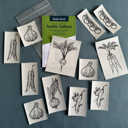 Textile tattoos with garden-themed designs on a blue gray background